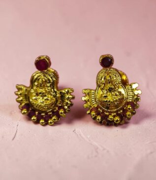 Celebrate tradition with these elegant Lakshmi Devi Stone Gold-Tone Stud Earrings, crafted to bring a divine and graceful charm to your jewelry collection. Featuring a beautifully detailed Lakshmi Devi motif at the center, these earrings symbolize prosperity, blessings, and timeless beauty. The rich gold-tone finish adds a luxurious shine, while the vibrant stone accent on top enhances their regal appeal. Designed with intricate craftsmanship, these traditional stud earrings are perfect for festive occasions, weddings, poojas, and cultural celebrations. Their lightweight and comfortable fit makes them ideal for long wear without compromising style. Pair them with sarees, lehengas, salwar suits, or ethnic gowns to complete your traditional look effortlessly. A perfect blend of devotion and fashion, these earrings also make a thoughtful gift for loved ones on special occasions like festivals, birthdays, and anniversaries. Add a touch of divine elegance to every outfit with these stunning Lakshmi Devi earrings.